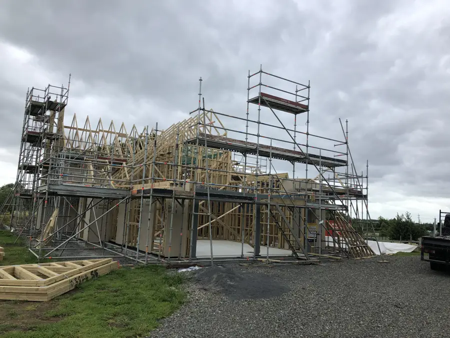 Scaffold platforms around the upper level of a house frame